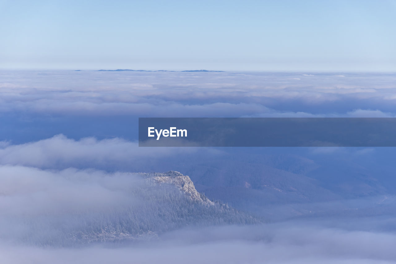 Aerial view of clouds over mountain against sky