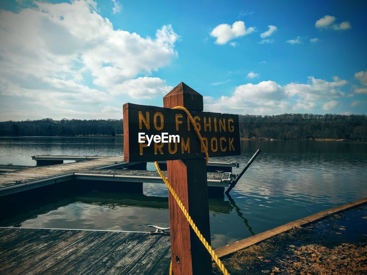 Sign board on pier at lake