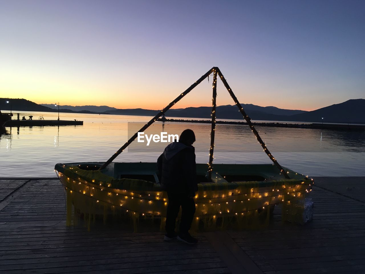 REAR VIEW OF SILHOUETTE MAN STANDING ON PIER