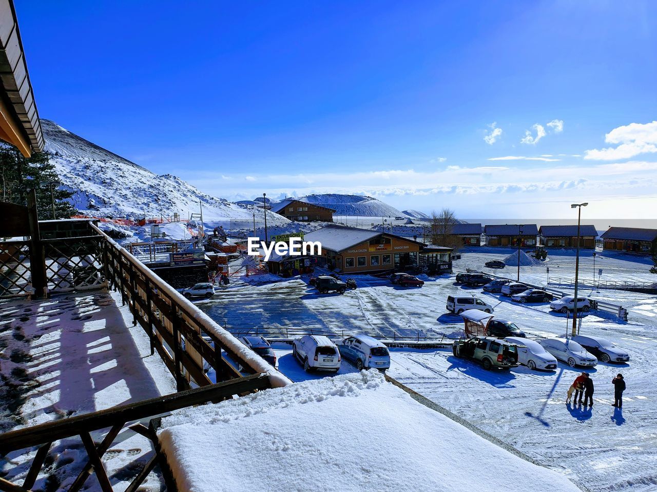 HIGH ANGLE VIEW OF SNOW COVERED HOUSES BY ROAD AGAINST SKY