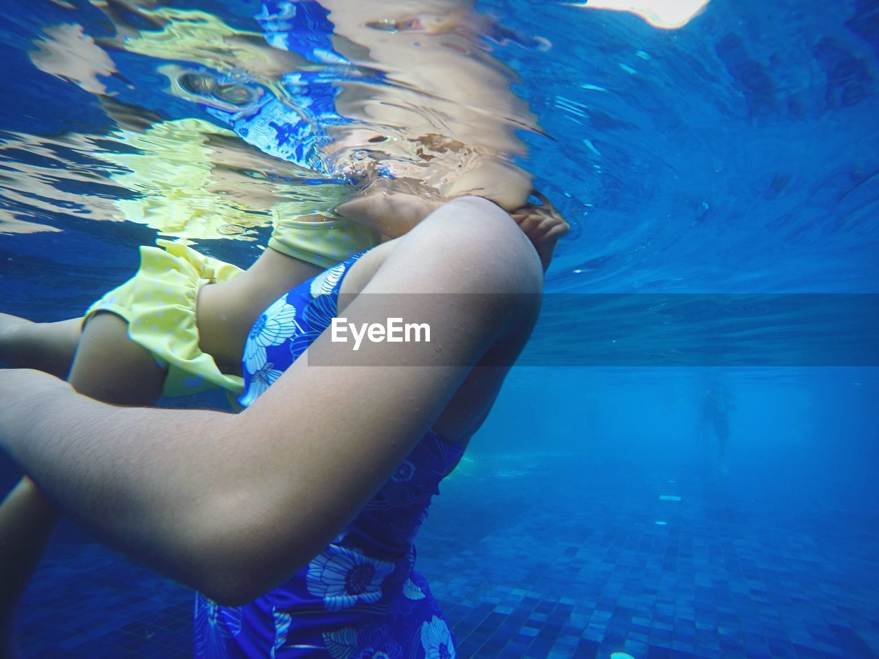 Side view of mother and daughter swimming in sea