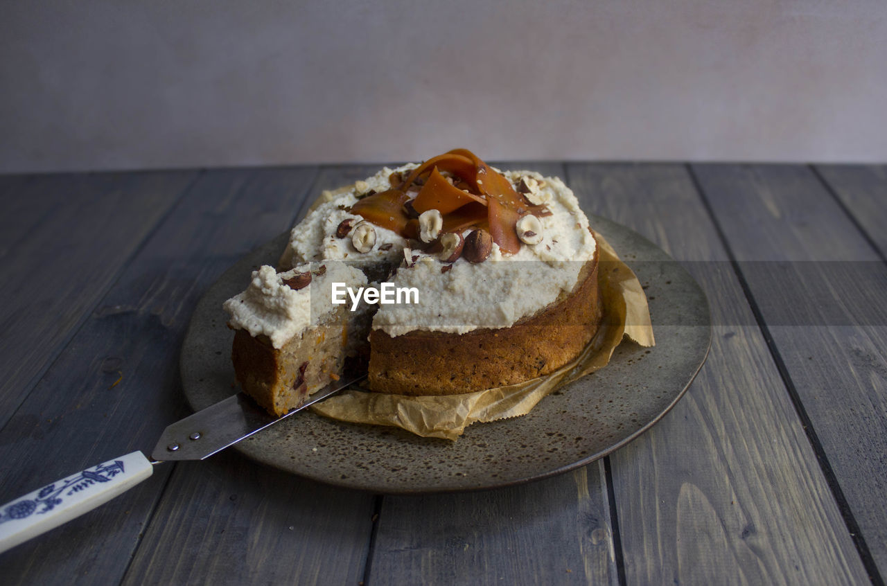 Close-up of carrot cake served on wooden table 