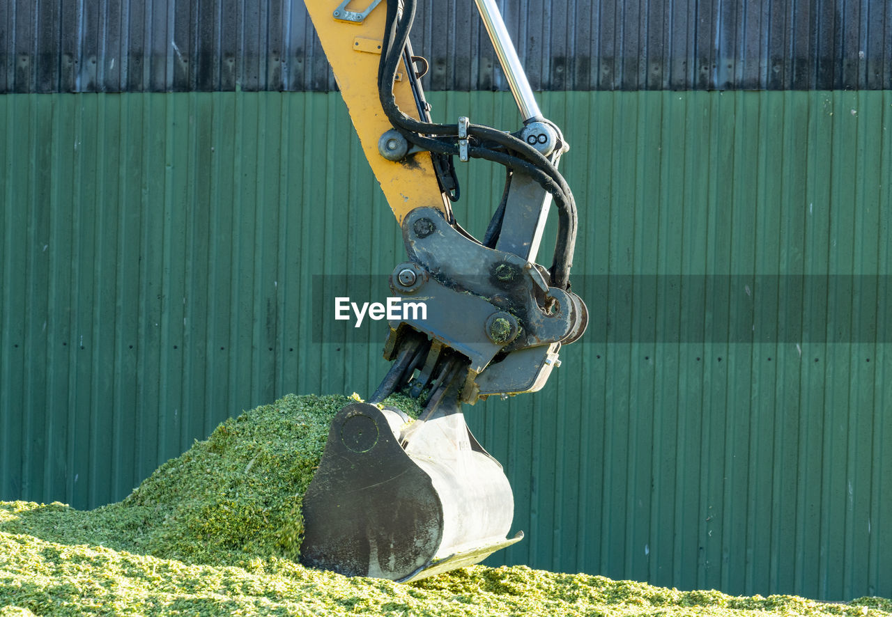 Excavator distributes corn on a corn silage during the corn harvest