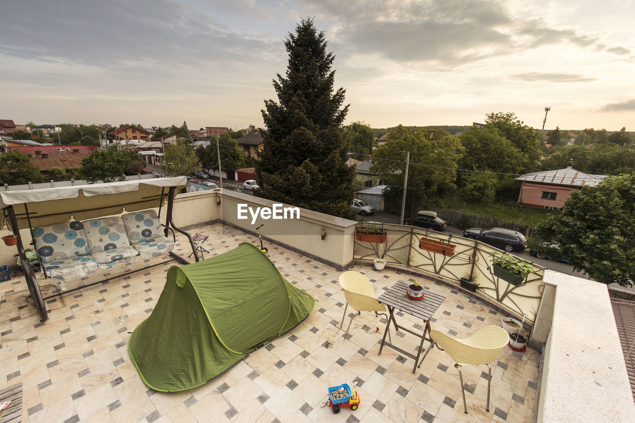 HIGH ANGLE VIEW OF HOUSES AND TREES AGAINST SKY