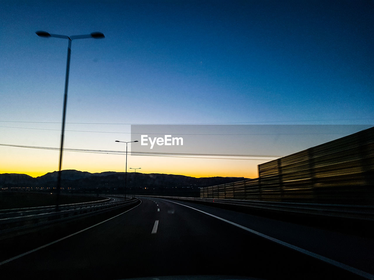 Road against clear sky at sunset