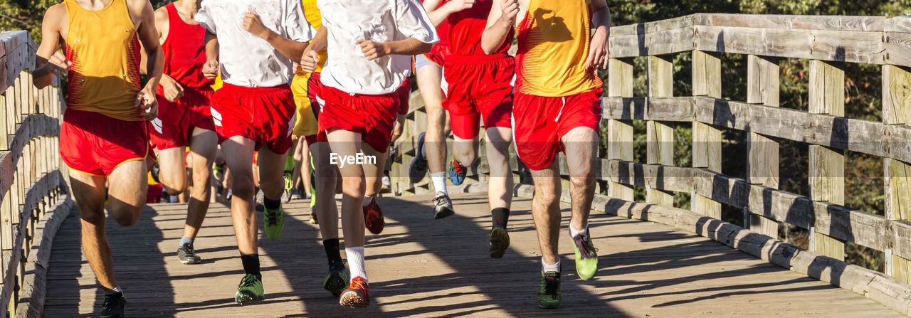 The leaders of a high school boys cross country race crossing over the bridge at sunken meadow.