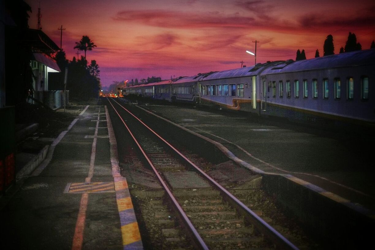 RAILROAD TRACKS AGAINST CLOUDY SKY