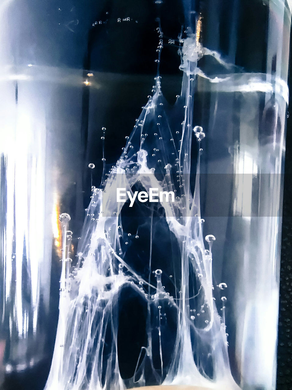 CLOSE-UP OF WATER SPLASHING IN DRINKING GLASS