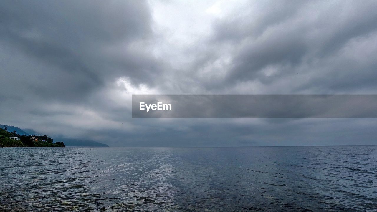 SCENIC VIEW OF SEA AGAINST STORM CLOUDS IN SKY