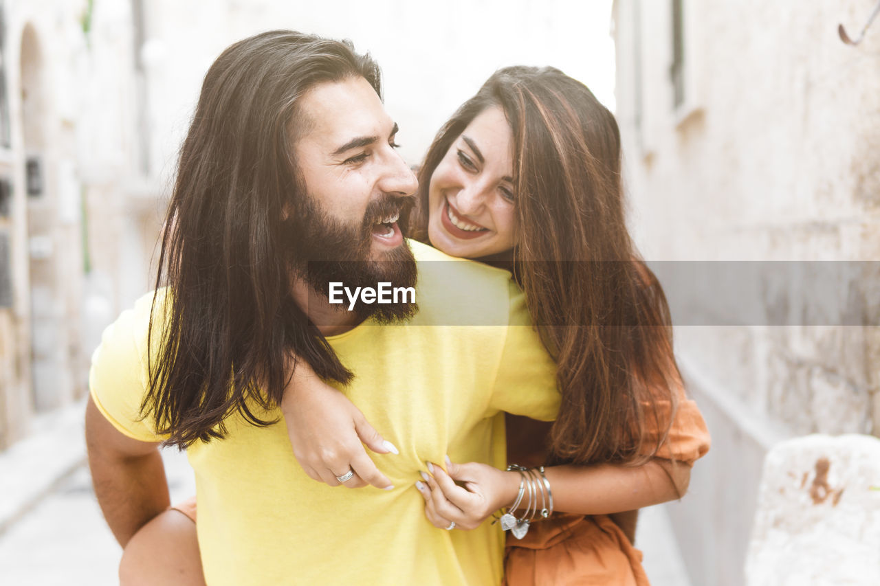 YOUNG COUPLE KISSING IN A WOMAN