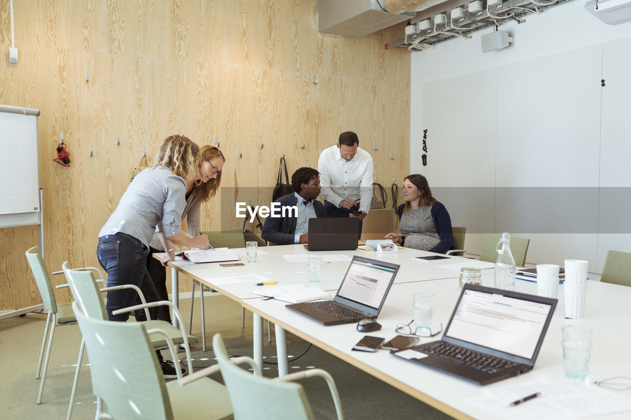 Male and female business coworkers discussing at conference table in meeting