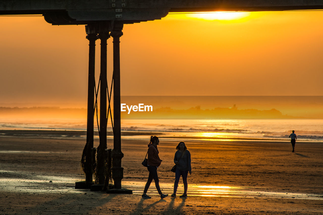 SILHOUETTE PEOPLE ON BEACH DURING SUNSET