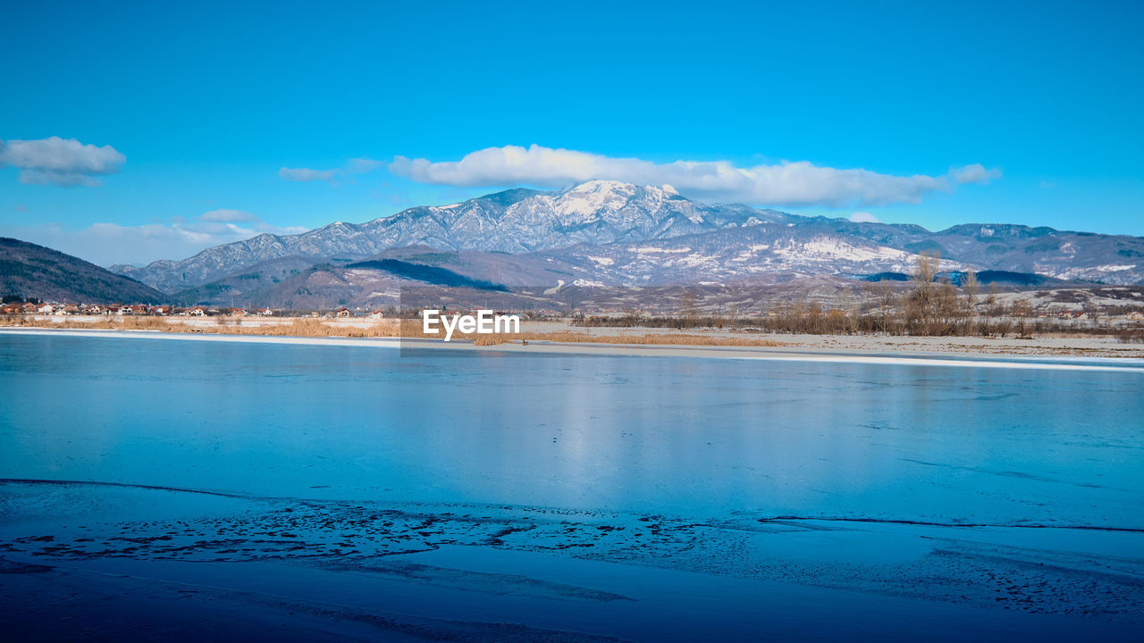 Scenic view of snowcapped mountains against blue sky