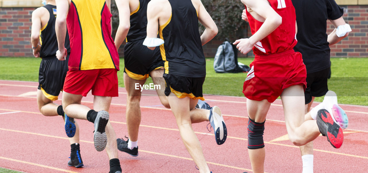 LOW SECTION VIEW OF PEOPLE RUNNING AT STADIUM