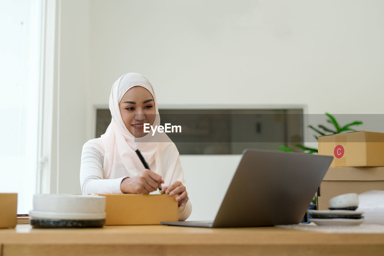 portrait of young woman using laptop on table