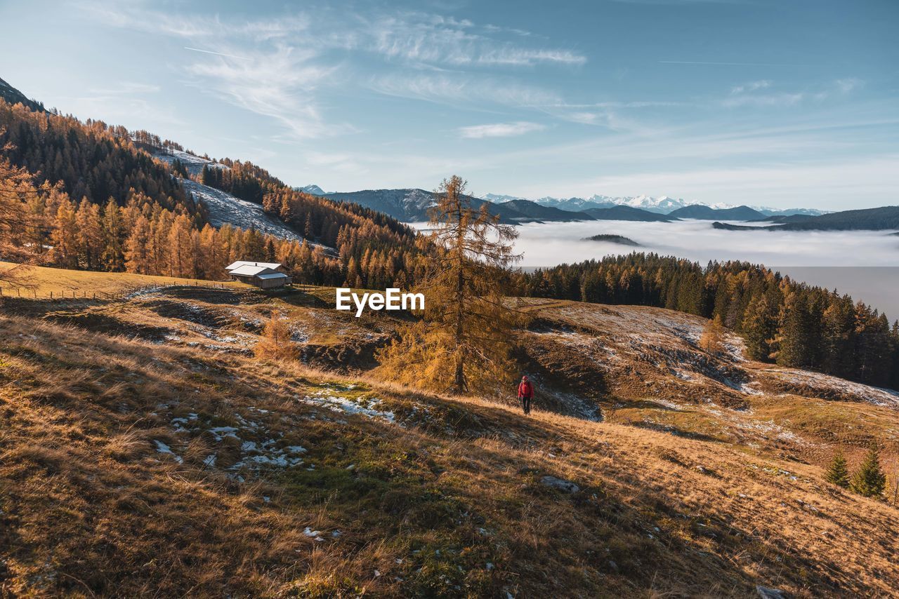 High angle view of woman hiking on mountain against sky during winter