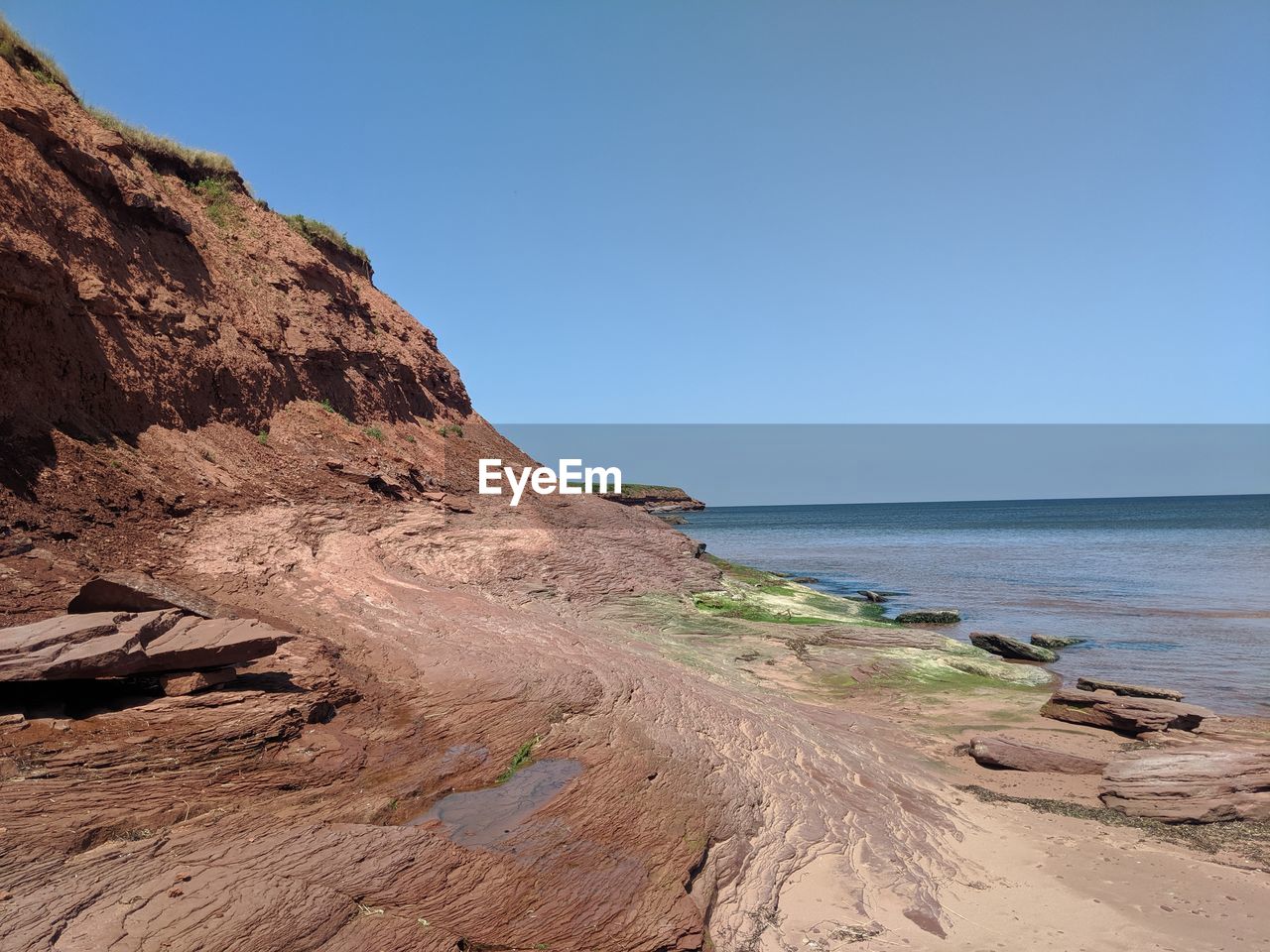 Scenic view of beach against clear blue sky