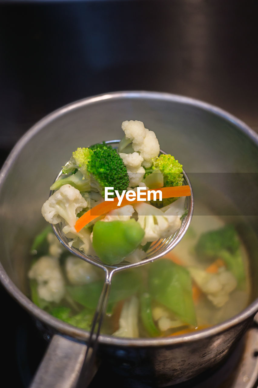 Close-up of vegetables in strainer over cooking utensil