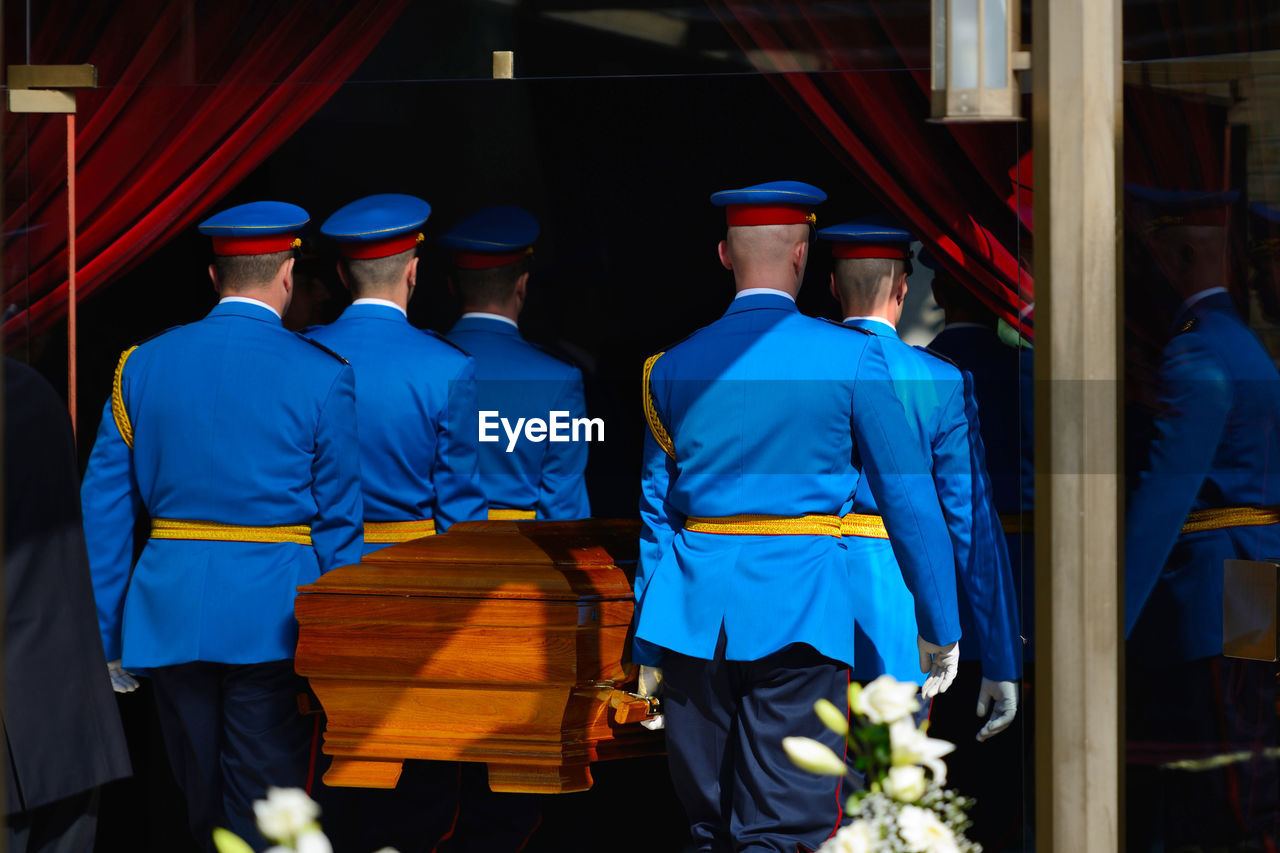 Rear view of of guards carrying coffin during funeral