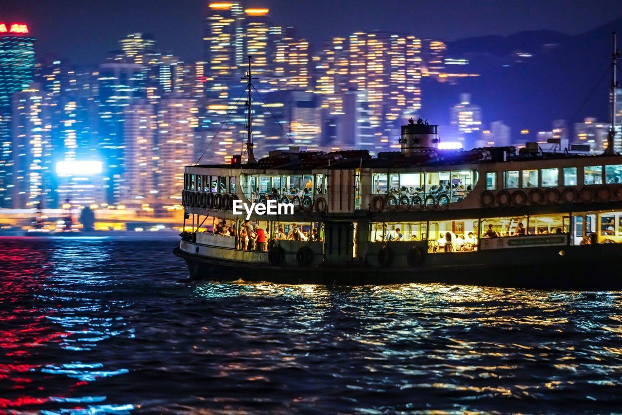 Illuminated buildings by sea at night