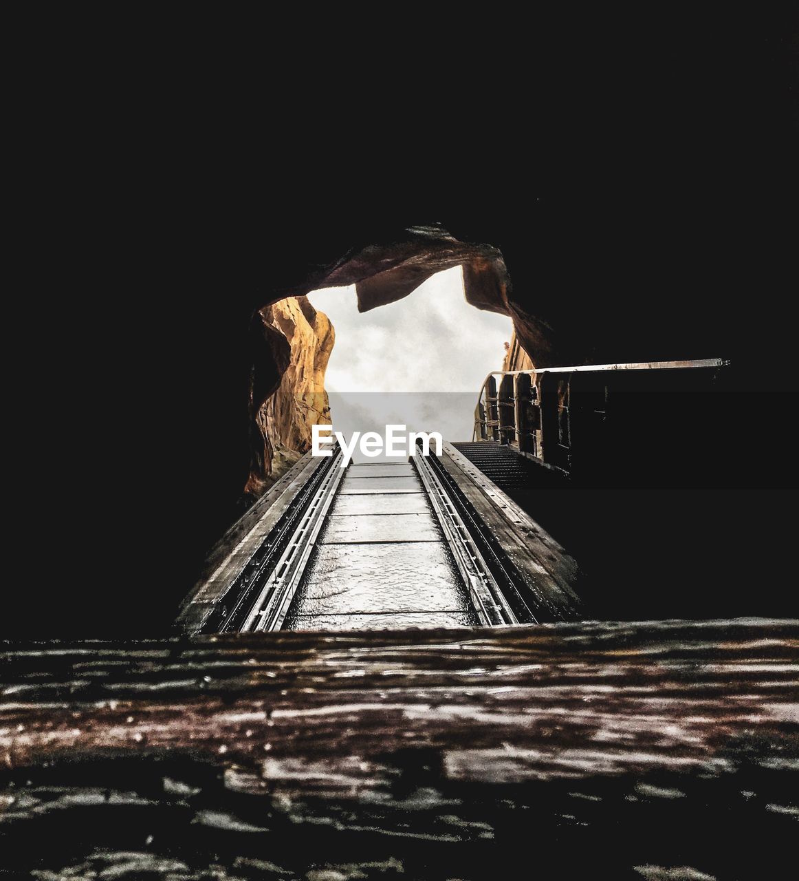 Cropped image of rollercoaster passing through tunnel against sky