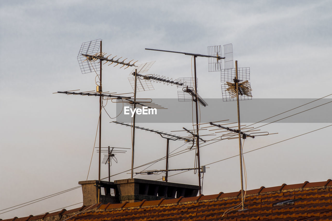 Low angle view of antennas against sky