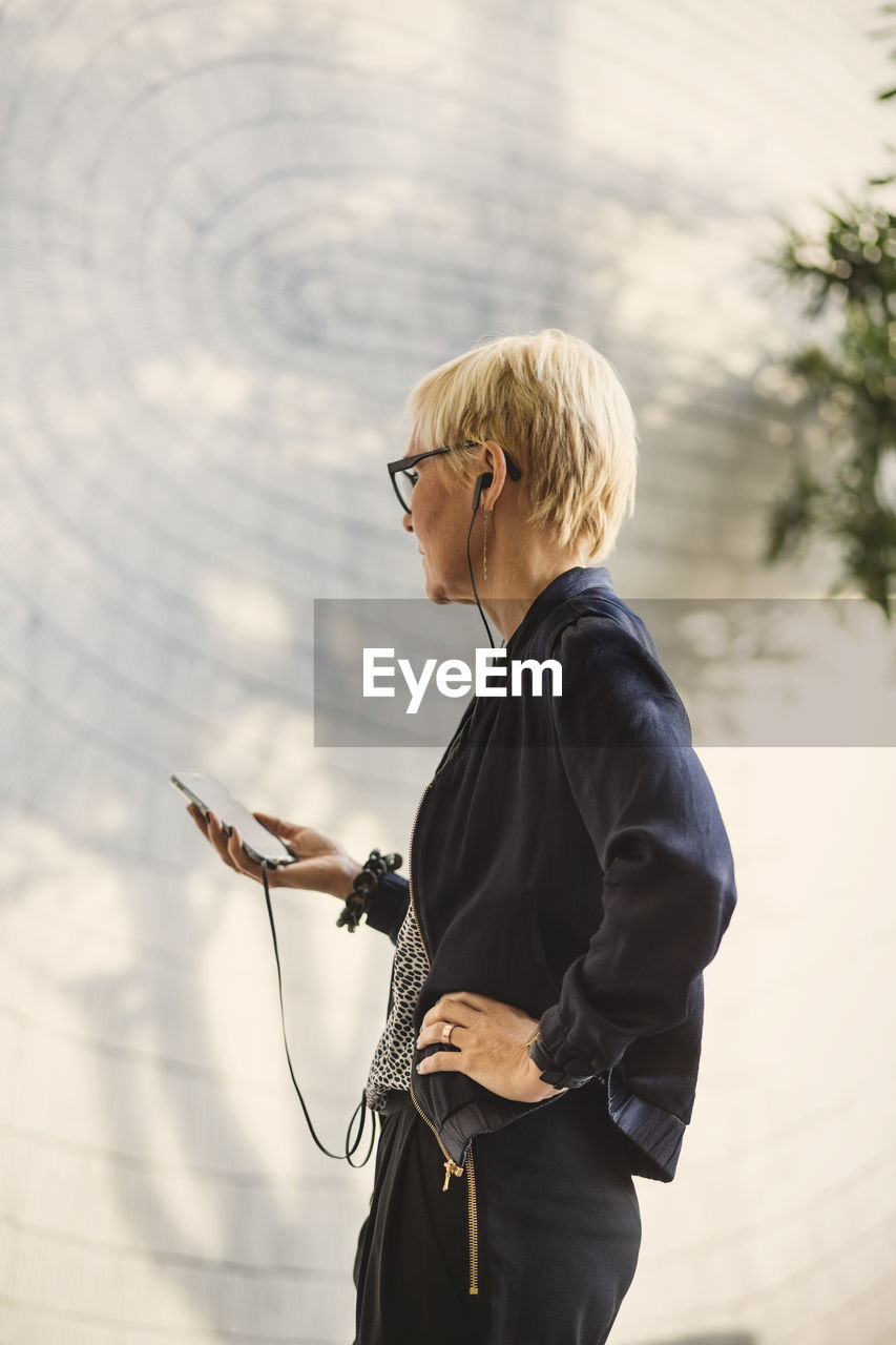 Mature businesswoman using mobile phone in creative office