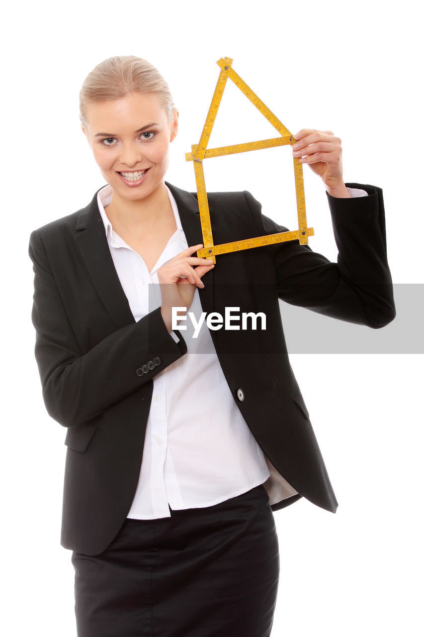 Close-up of businesswoman with piggy bank against white background