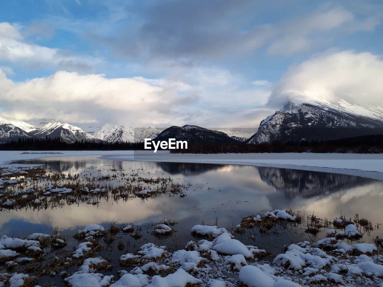 SCENIC VIEW OF LAKE BY SNOWCAPPED MOUNTAINS AGAINST SKY DURING WINTER