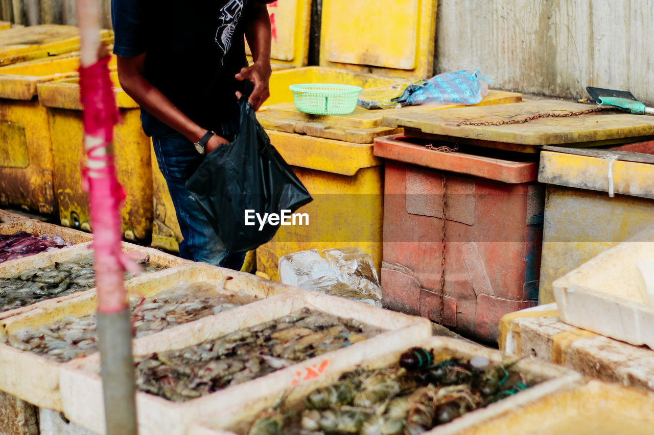 Midsection of man standing at fish market