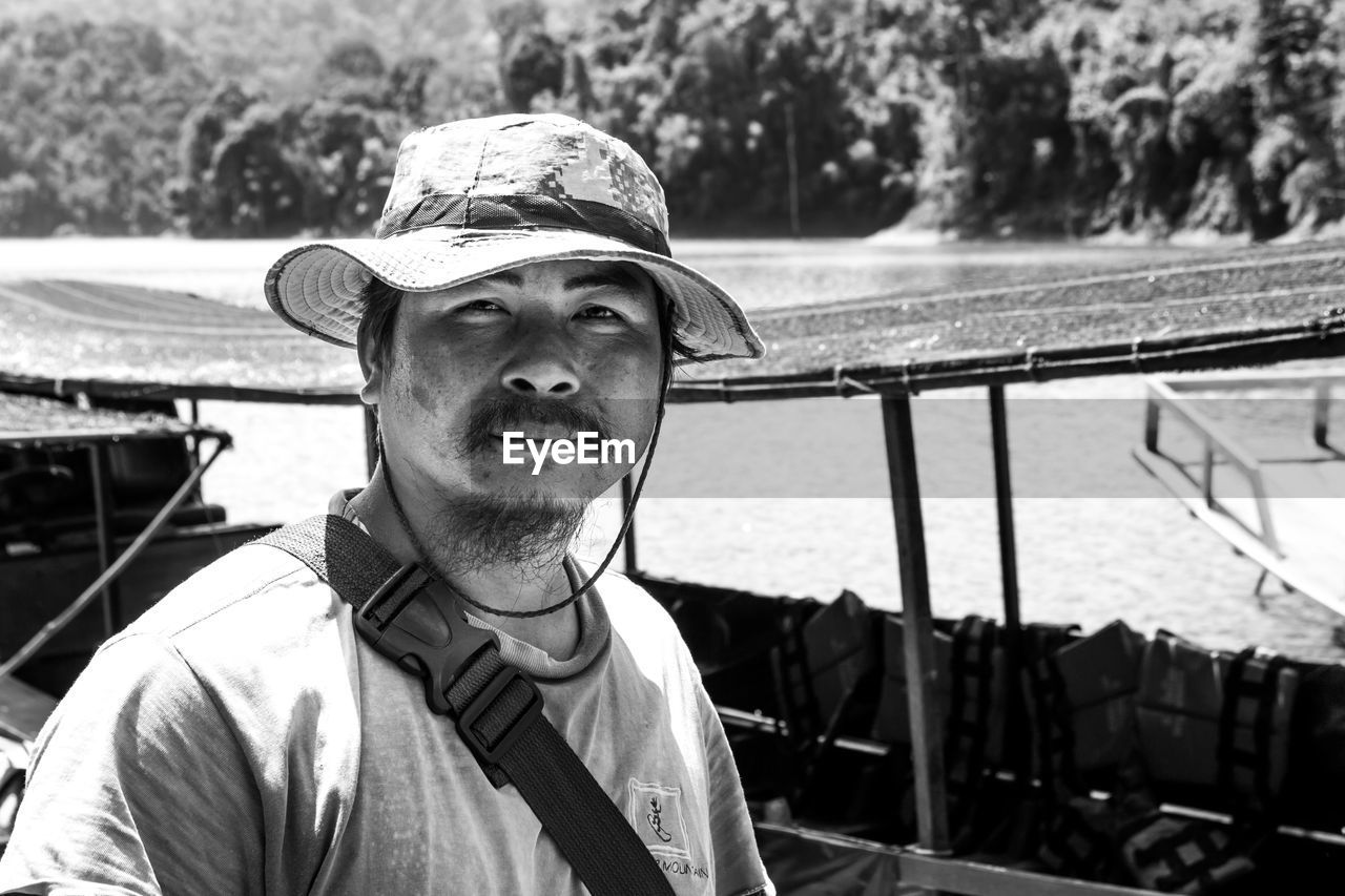 PORTRAIT OF MAN WEARING HAT WHILE SITTING ON CAR