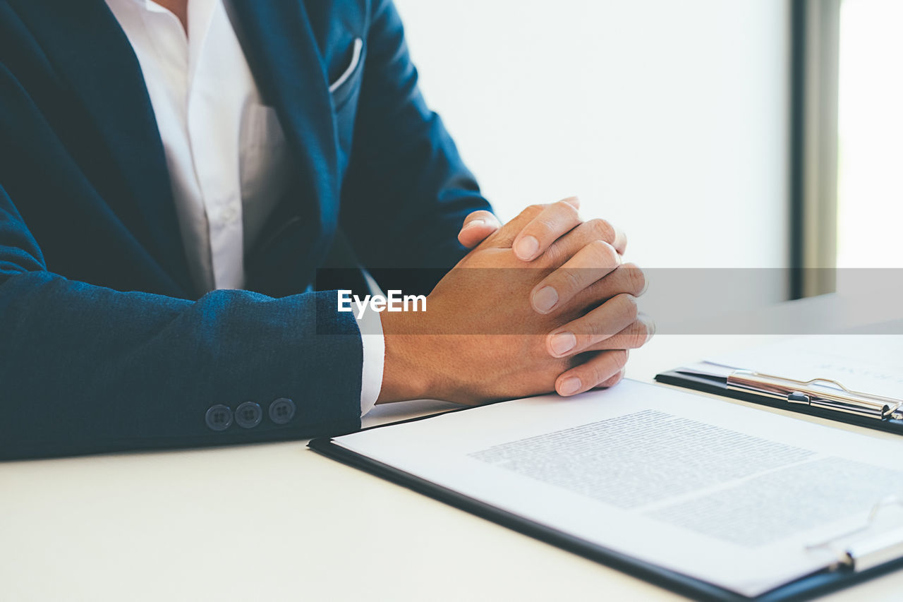 CLOSE-UP OF MAN WORKING IN PEN ON TABLE