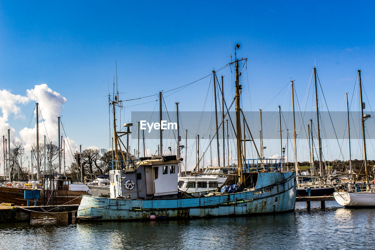 SAILBOATS MOORED IN HARBOR