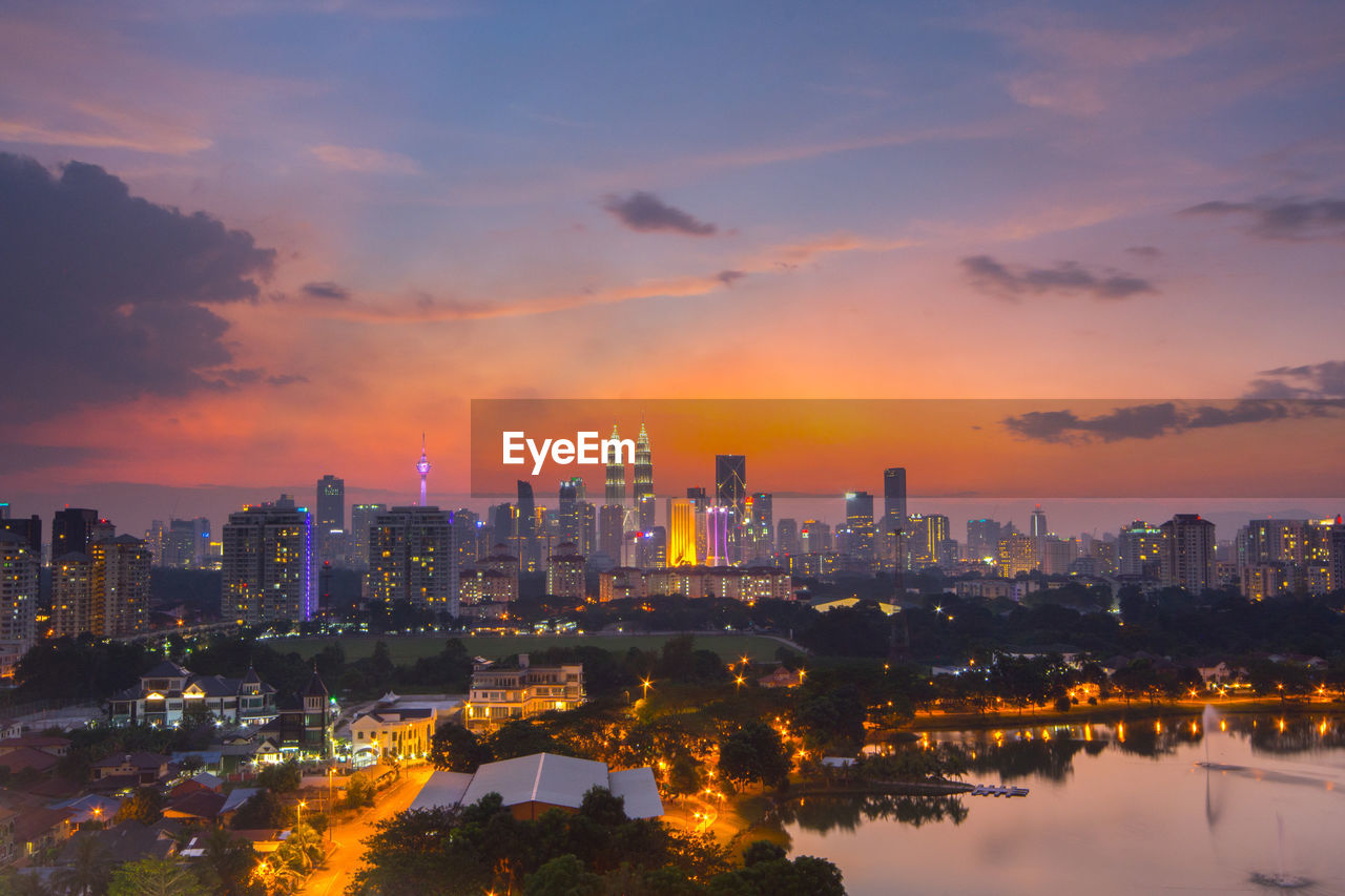 Distant view of petronas towers against sky during sunset in city