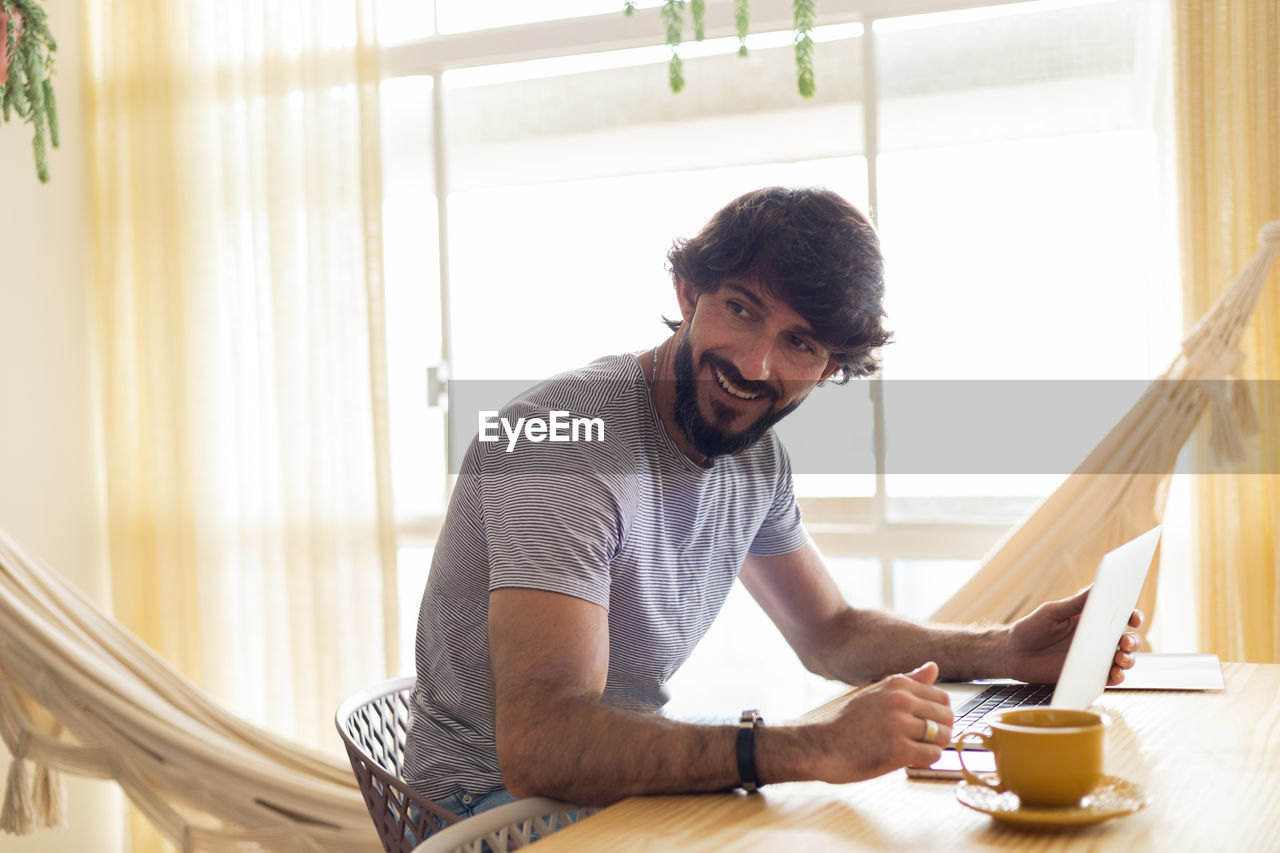 Young business man working at home in his kitchen with laptop. gray notebook. home office 