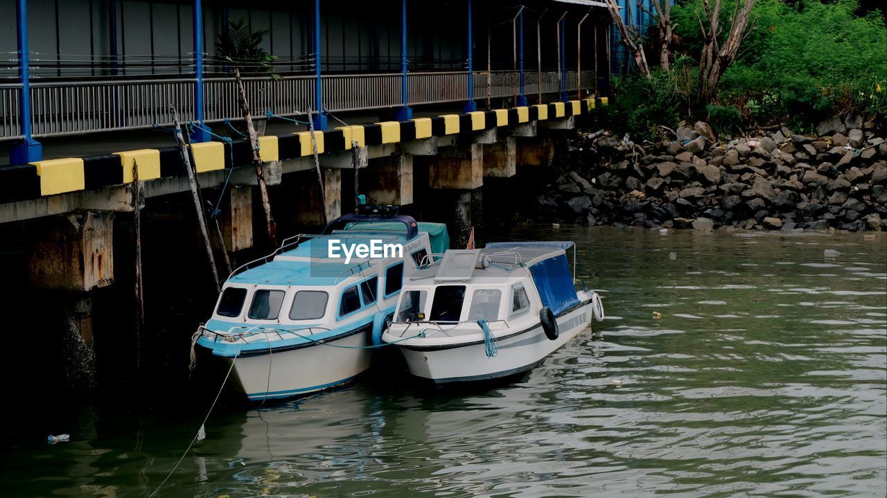 Sailboats moored on river