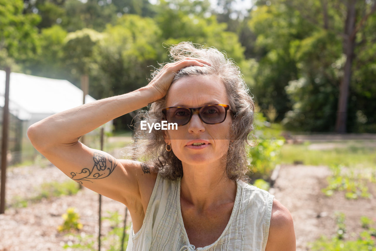 Portrait of mature woman wearing sunglasses on field