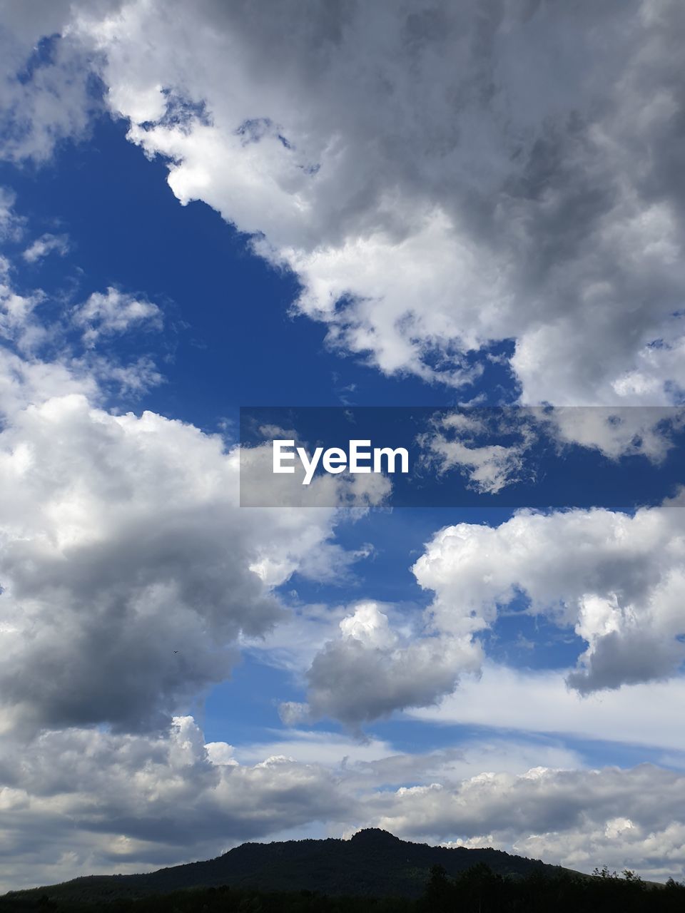 LOW ANGLE VIEW OF CLOUDS OVER MOUNTAIN