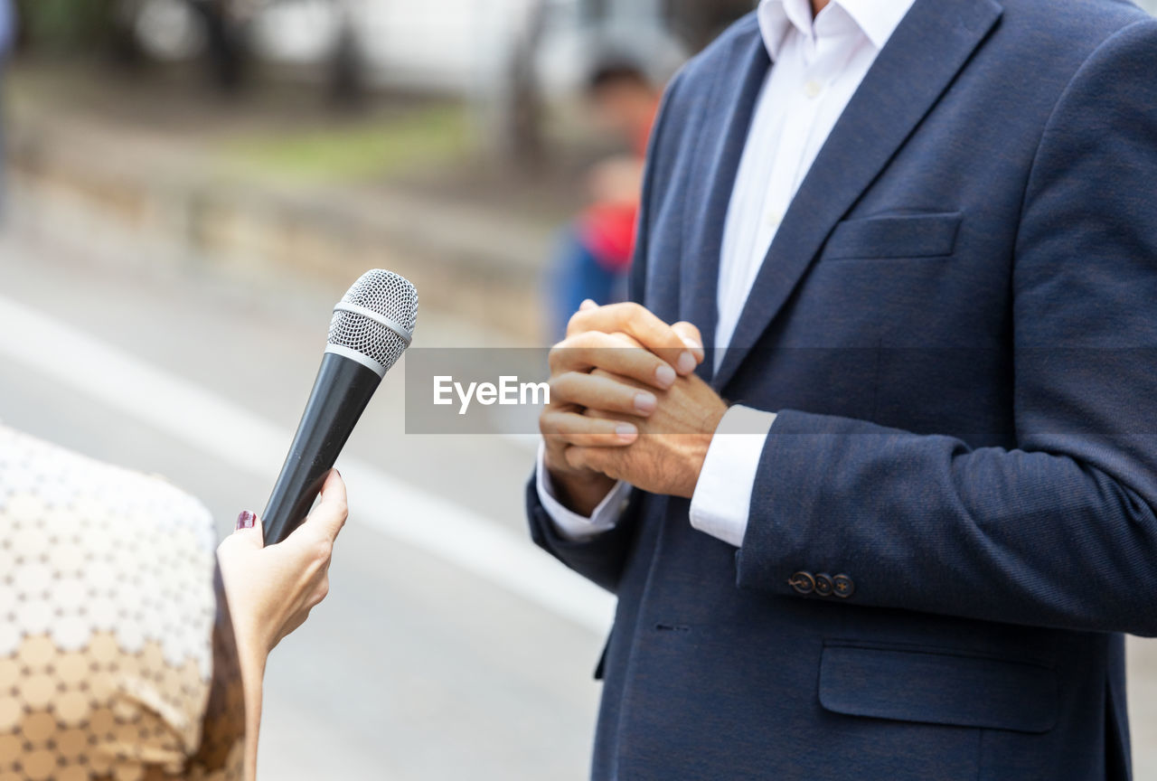 Journalist making media interview with unrecognizable person. vox populi concept.