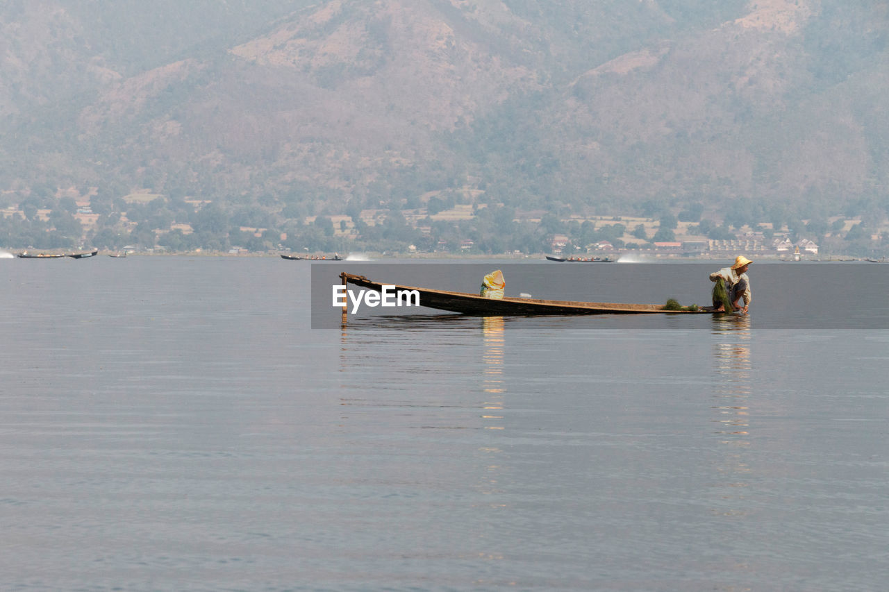 SHIP IN SEA AGAINST MOUNTAINS