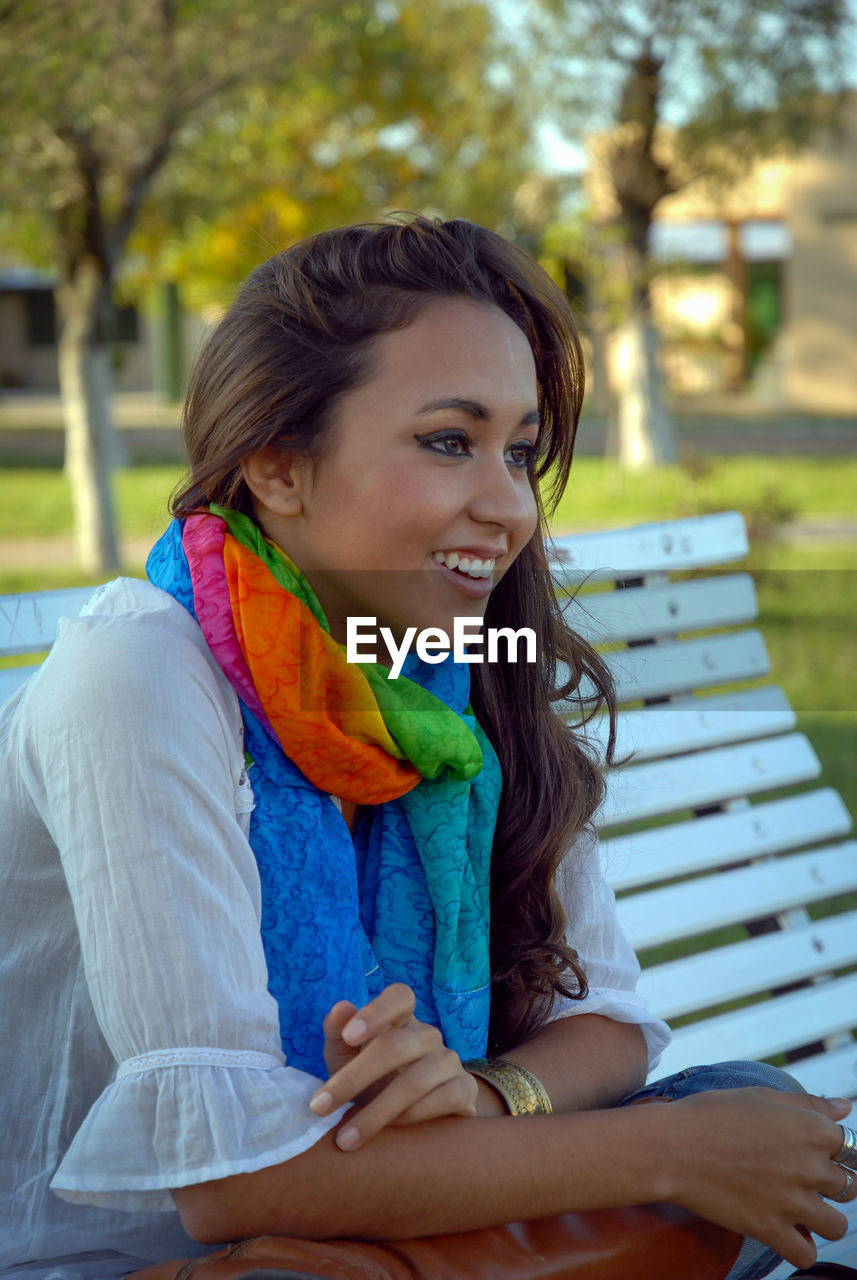 Portrait of a smiling young woman sitting on bench