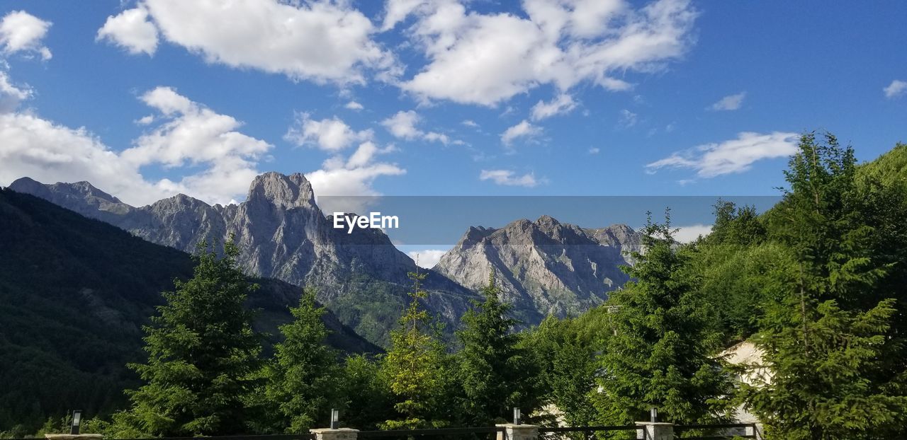 SCENIC VIEW OF MOUNTAINS AGAINST CLOUDY SKY