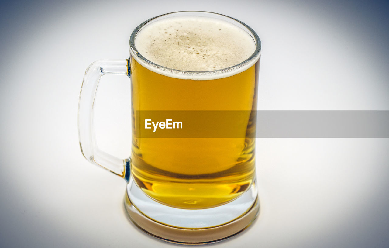 CLOSE-UP OF BEER IN GLASS ON TABLE