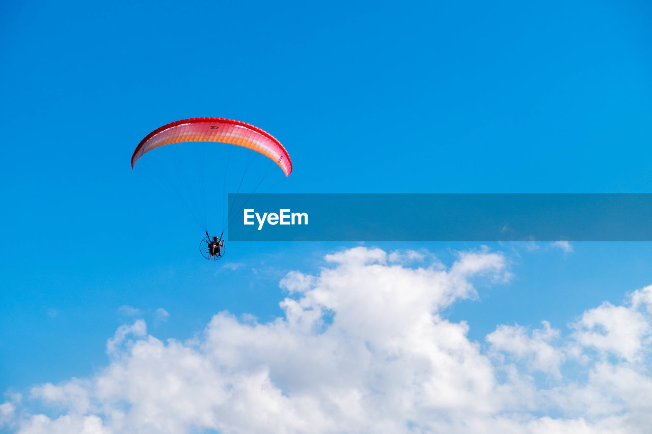 low angle view of person paragliding against clear blue sky
