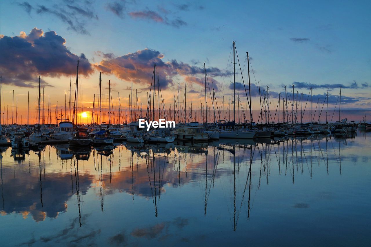 Sailboats in marina at sunset