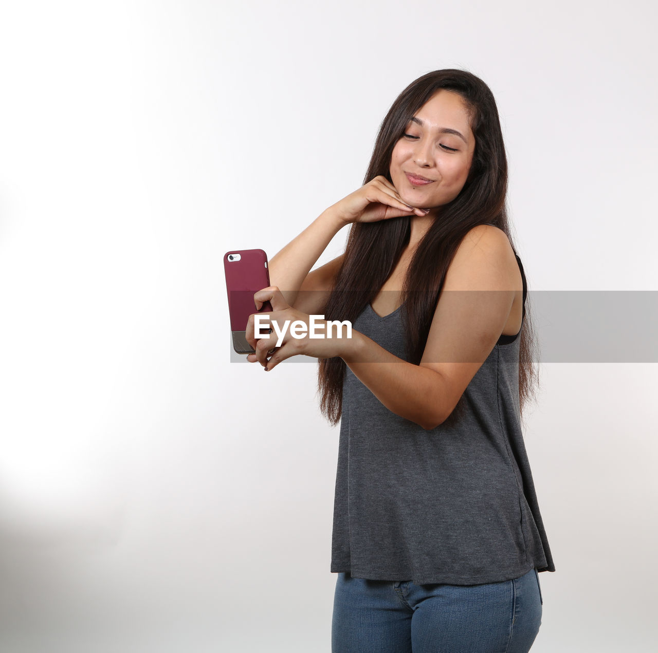 YOUNG WOMAN USING MOBILE PHONE WHILE STANDING ON CAMERA