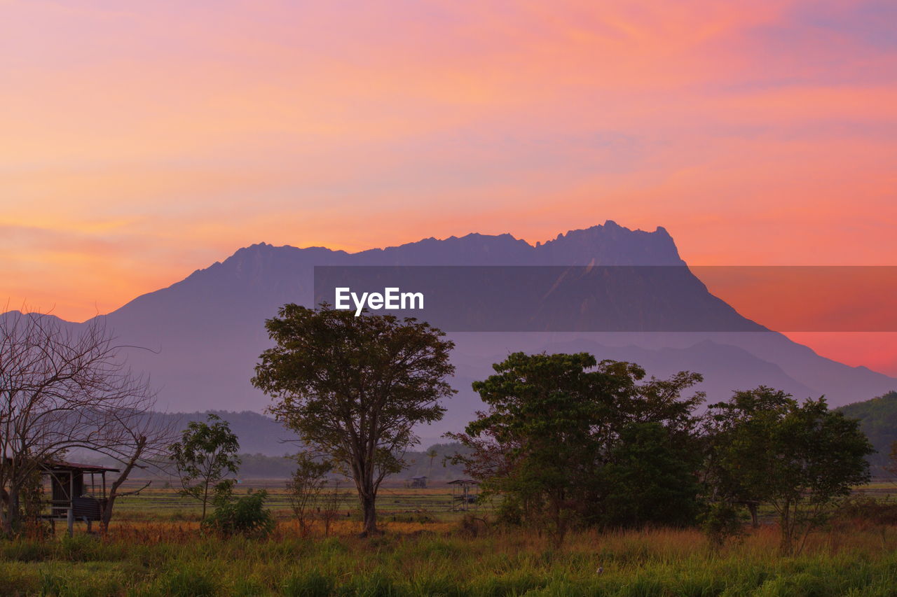 SCENIC VIEW OF MOUNTAINS AGAINST ORANGE SKY