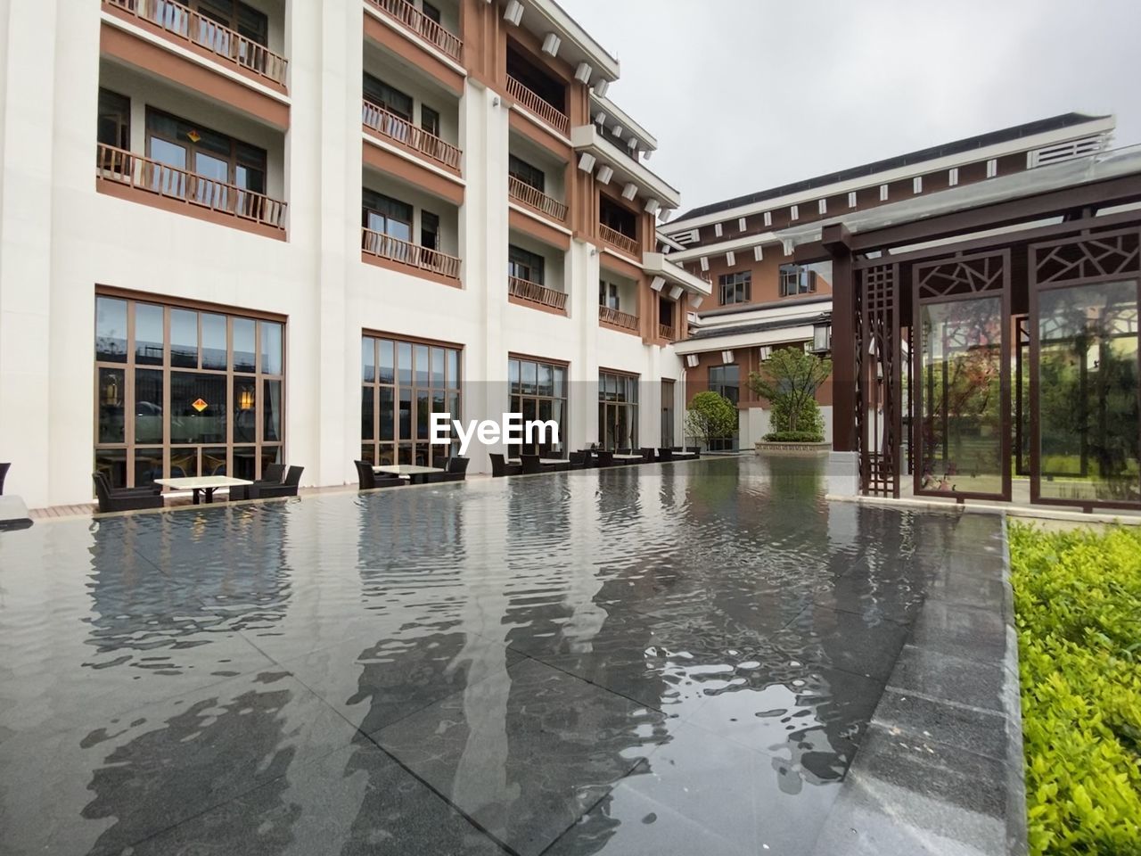 Reflection of buildings on wet street in rainy season