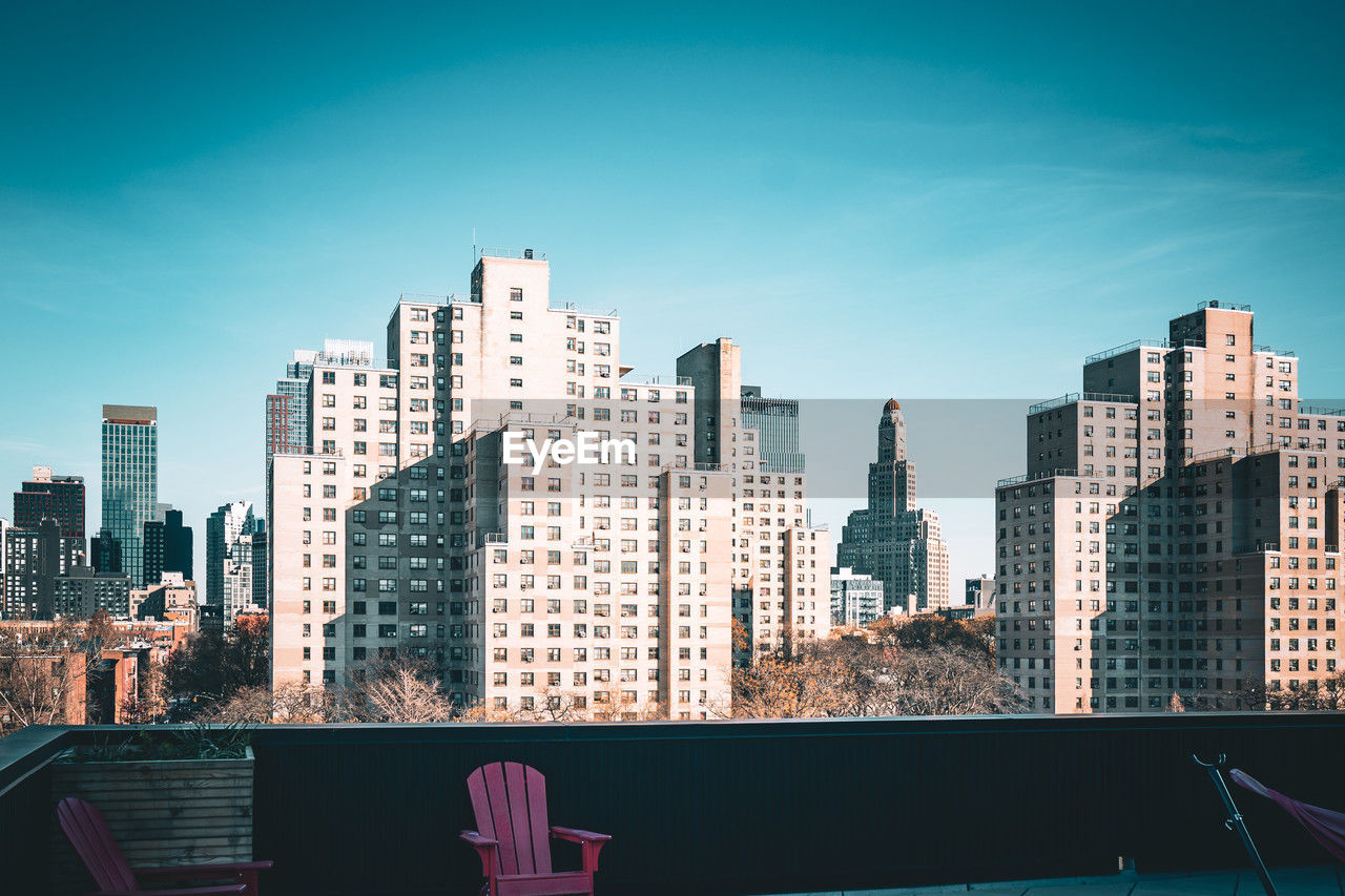 View of modern tall buildings and traditional apartment buildings seen from deck in brooklyn, ny