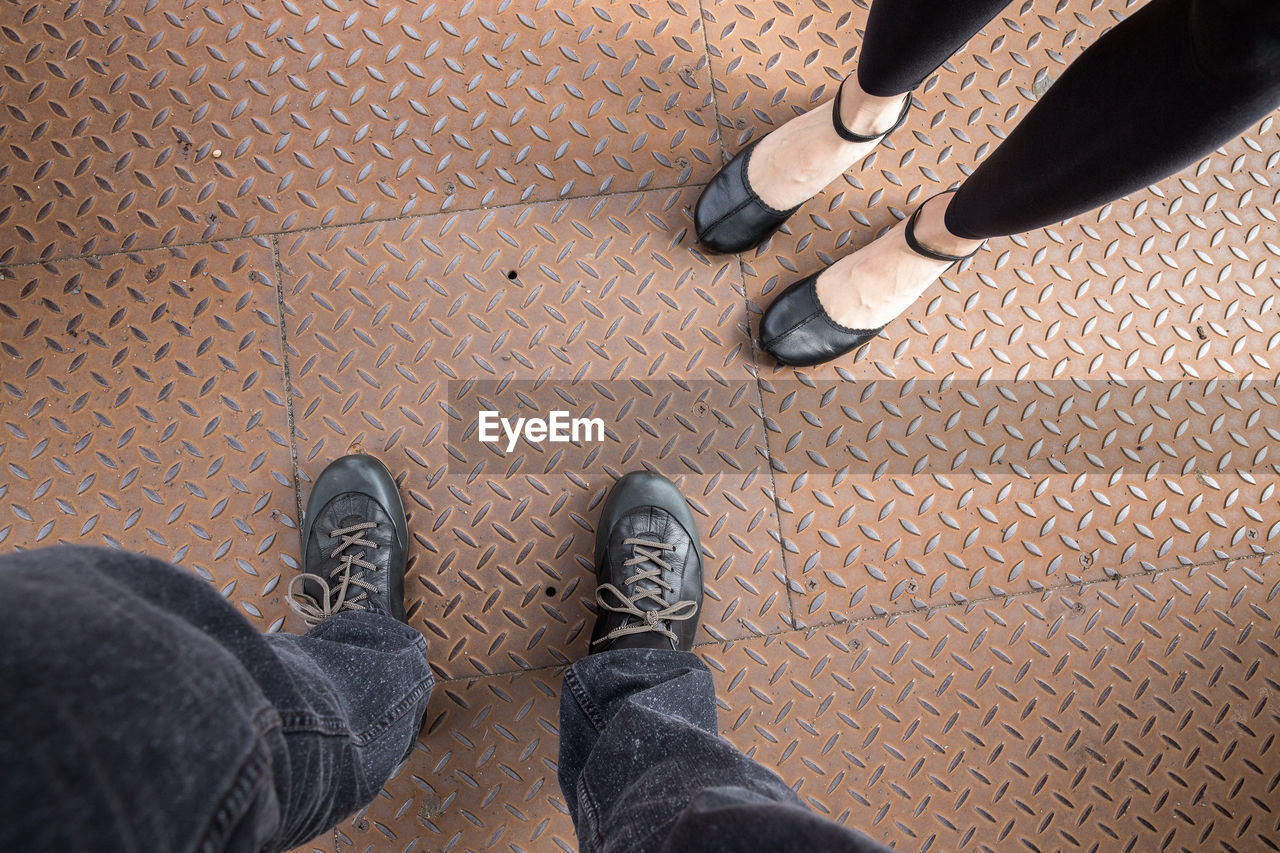 Low section of people standing on diamond plate